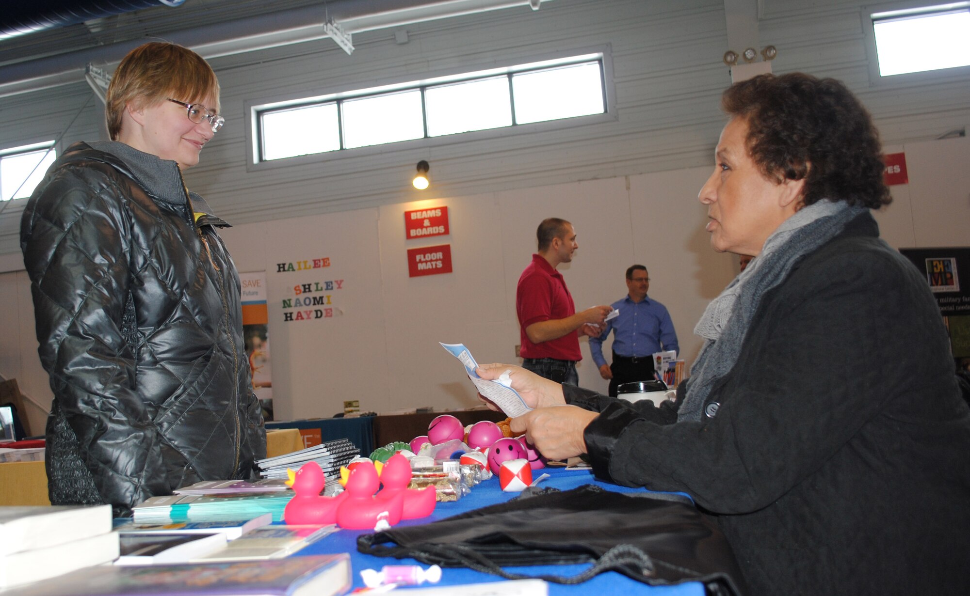 Karen Greyeyes, Family Advocacy outreach manager, shows Tech. Sgt. Stephanie Thompson, 319th Communications Squadron, some of the free literature provided for guests attending the 2014 Financial Information Fair held Feb. 20, 2014, at Liberty Square on Grand Forks Air Force Base, N.D. The fair consisted of booths manned by representatives from more than a dozen on- and off-base organizations ready to provide answers and information regarding financial matters and other military life topics, such as managing financial stress. (U.S. Air Force photo/Staff Sgt. Luis Loza Gutierrez)