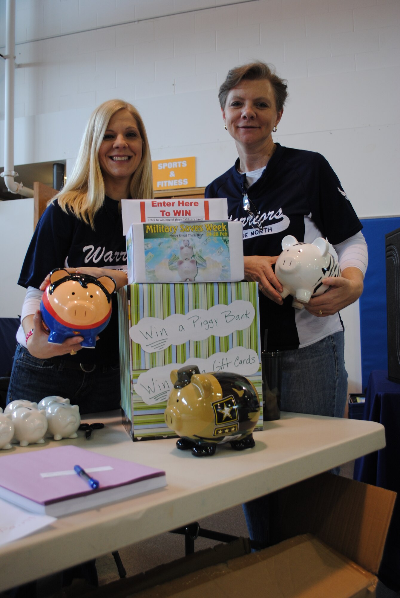 Key Spouses Group members Bonnie Bauman and Becky Duncan take a photo with
custom-painted piggy banks during the 2014 Kids' Financial Day on Feb. 20, 2014, at Liberty Square on Grand Forks Air Force Base, N.D. The three large custom-painted piggy banks were given away as prizes in a free raffle drawing. Gift certificates for a free large pizza from JR Rockers were also given away with each of the piggy banks. The certificates were donated by the Northern Lights Club. (U.S. Air Force photo/Staff Sgt. Luis Loza Gutierrez)
