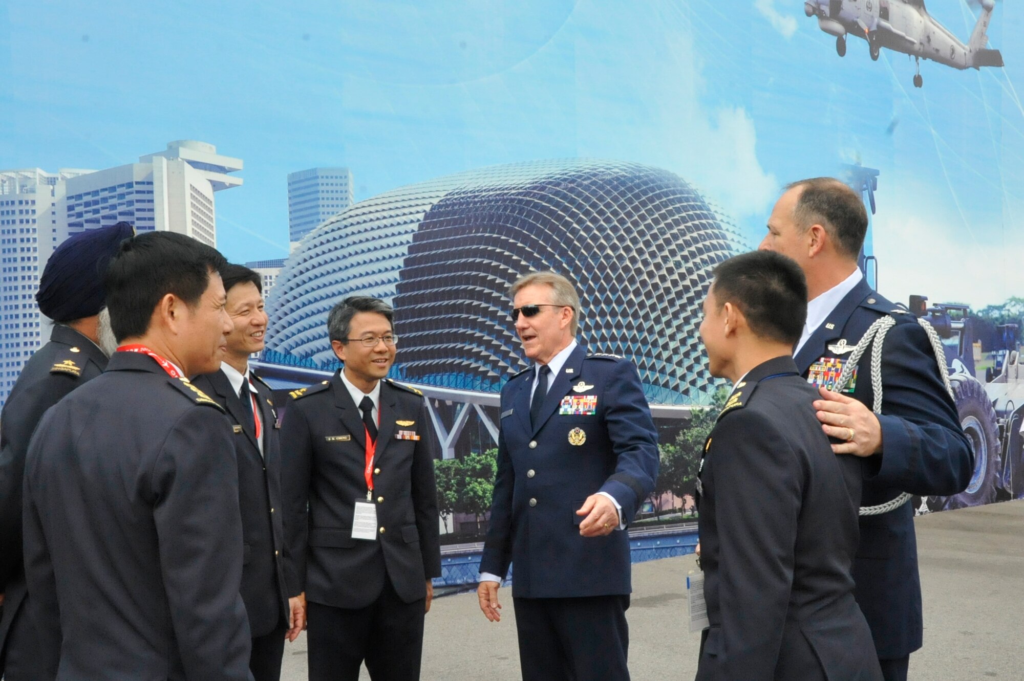 Gen. Hawk Carlisle (middle), Pacific Air Forces commander, discusses the upcoming events of the 2014 Singapore International Airshow with Singapore Air Force members outside of the Changi Exhibition Centre, Singapore, Feb. 11, 2014. The U.S. Air Force showcased the C-17 Globemaster III, the F-16 Fighting Falcon and the KC-135 Stratotanker at the event. (U.S. Air Force photo/Capt. Tamara Fischer-Carter)