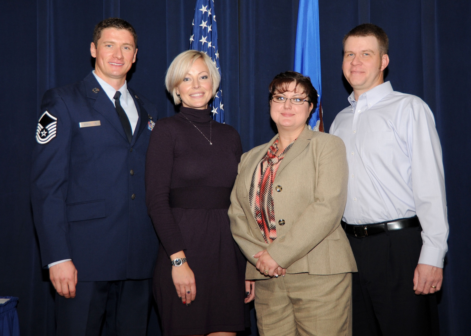 Master Sgt. Jeffrey Braselton, 944th Force Support Squadron Chief, personnel systems management, and his wife Victoria pose for a picture with Kelley Williams, son of the late Graydon Williams and his wife Amy during the Graydon Williams Ceremony at Club Five Six, Luke Air Force Base, Ariz. Braselton took home this year's award. (U.S. Air Force photo/Tech. Sgt. Louis Vega Jr.)