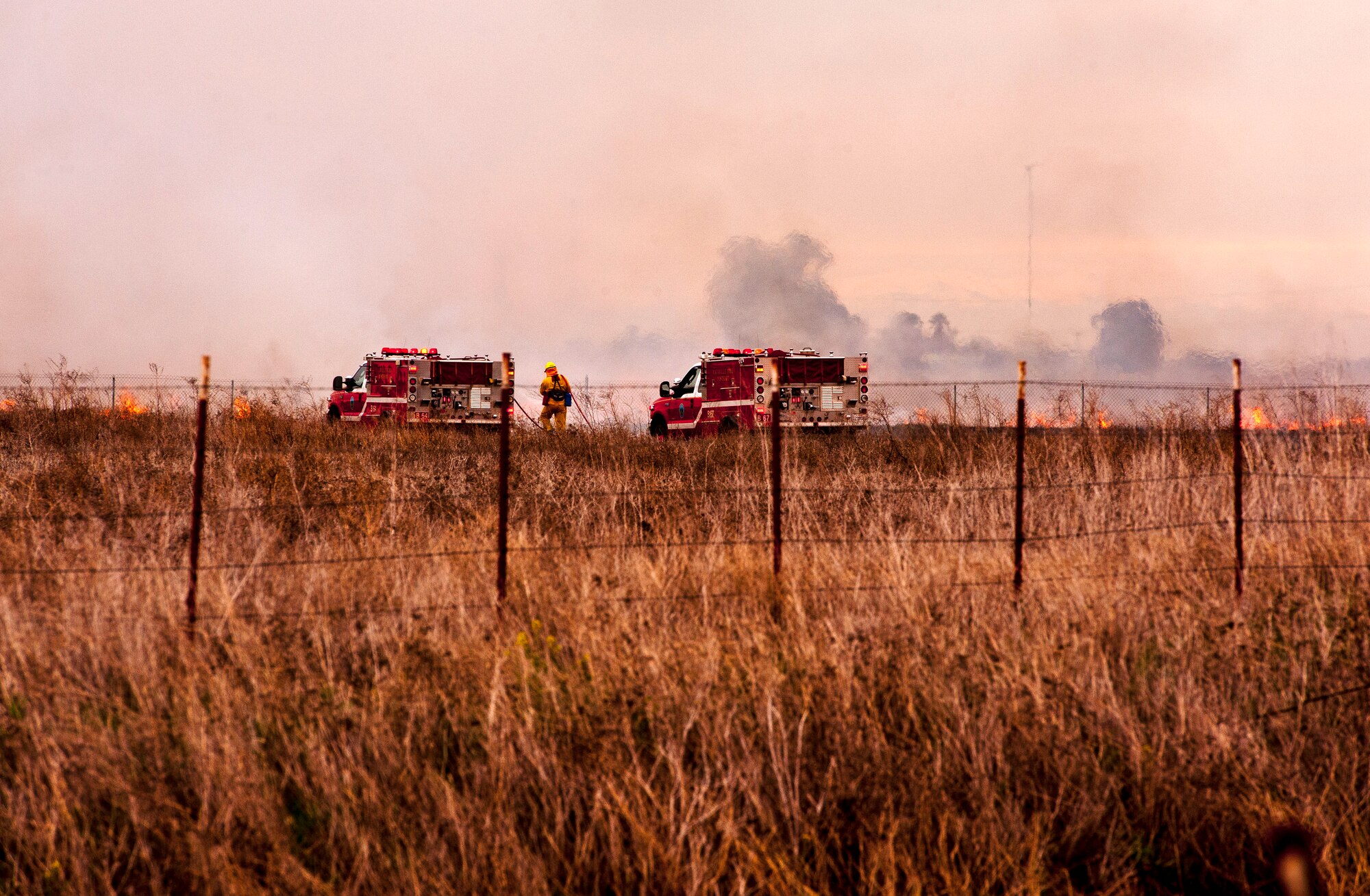 Travis and local firefighters fight a grass fire to keep it from spreading to adjacent areas, between Hay and Lewis roads Feb. 18 in Vacaville, Calif. (U.S. Air Force photo/Tech. Sgt. Matthew Hannen)