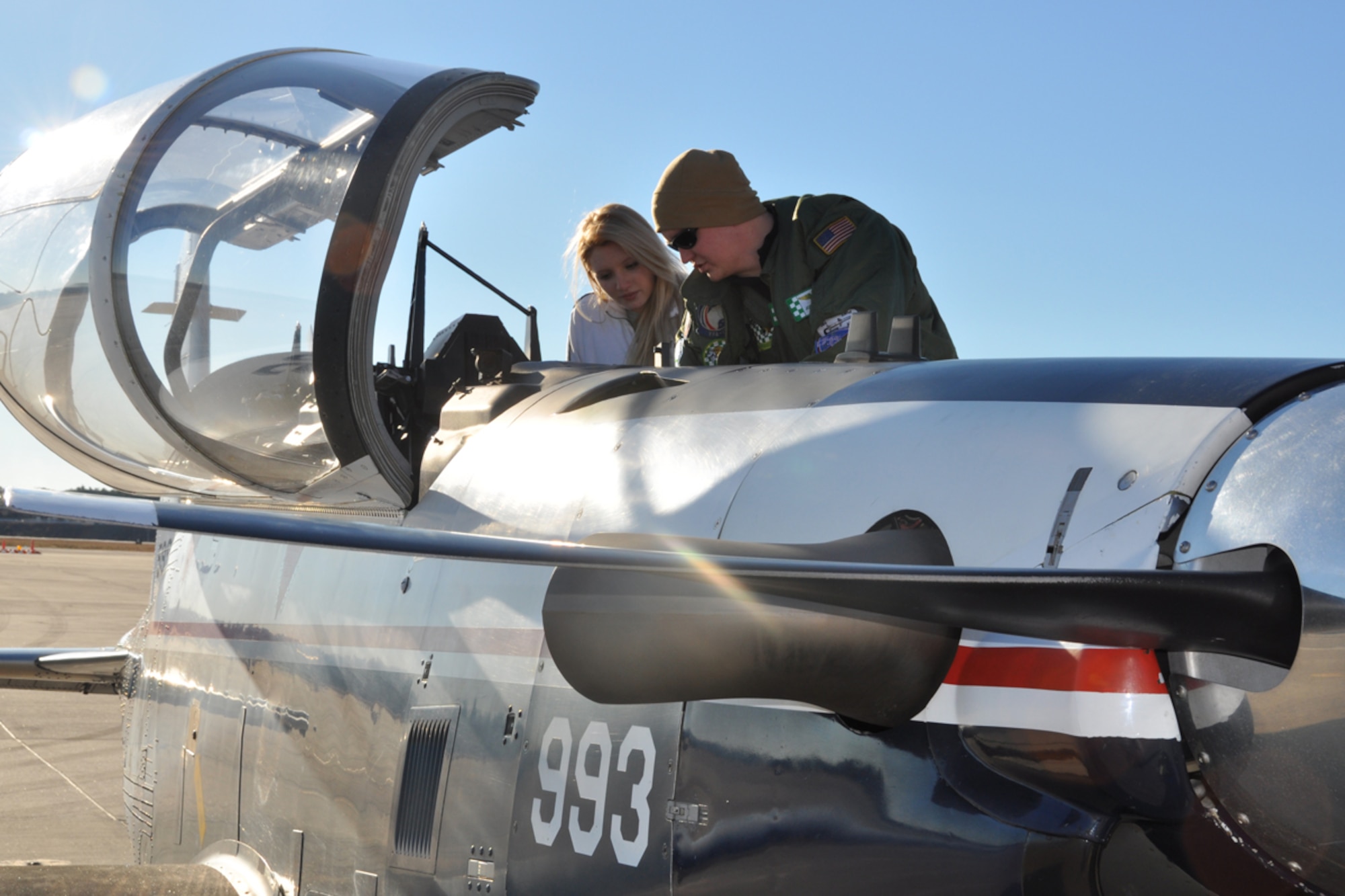 U.S. Navy Lt. Jordan Brown, pilot, Naval Air Station Pensacola, Fla., gives Brianna Van Gordon, Lassiter High School sophomore and JROTC cadet, a tour of a T-6B Texan II aircraft upon landing at Dobbins Air Reserve Base, Jan. 22. The T-6 Texan II is a tandem seat, turboprop trainer. Its primary mission is to train Navy and USMC pilots. Brown discussed opportunities in naval aviation with JROTC cadets. (U.S. Air Force photo/James Branch)