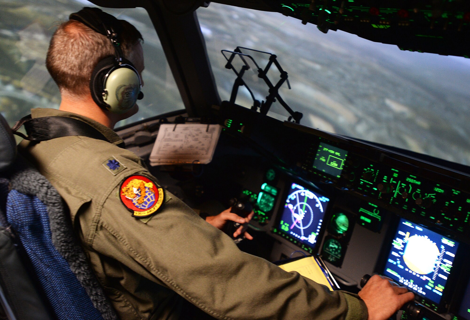 Lt. Col. Gregg Johnson, 535th Airlift Squadron commander, banks left in a C-17 Globemaster III simulator during a quarterly training session at Joint Base Pearl Harbor-Hickam, Hawaii, Feb. 18, 2014. Johnson is a C-17 pilot, and trains extensively using the simulator, designed to give pilots a realistic feel for in-air tactical and emergency operations. (U.S. Air Force photo/Staff Sgt. Alexander Martinez)