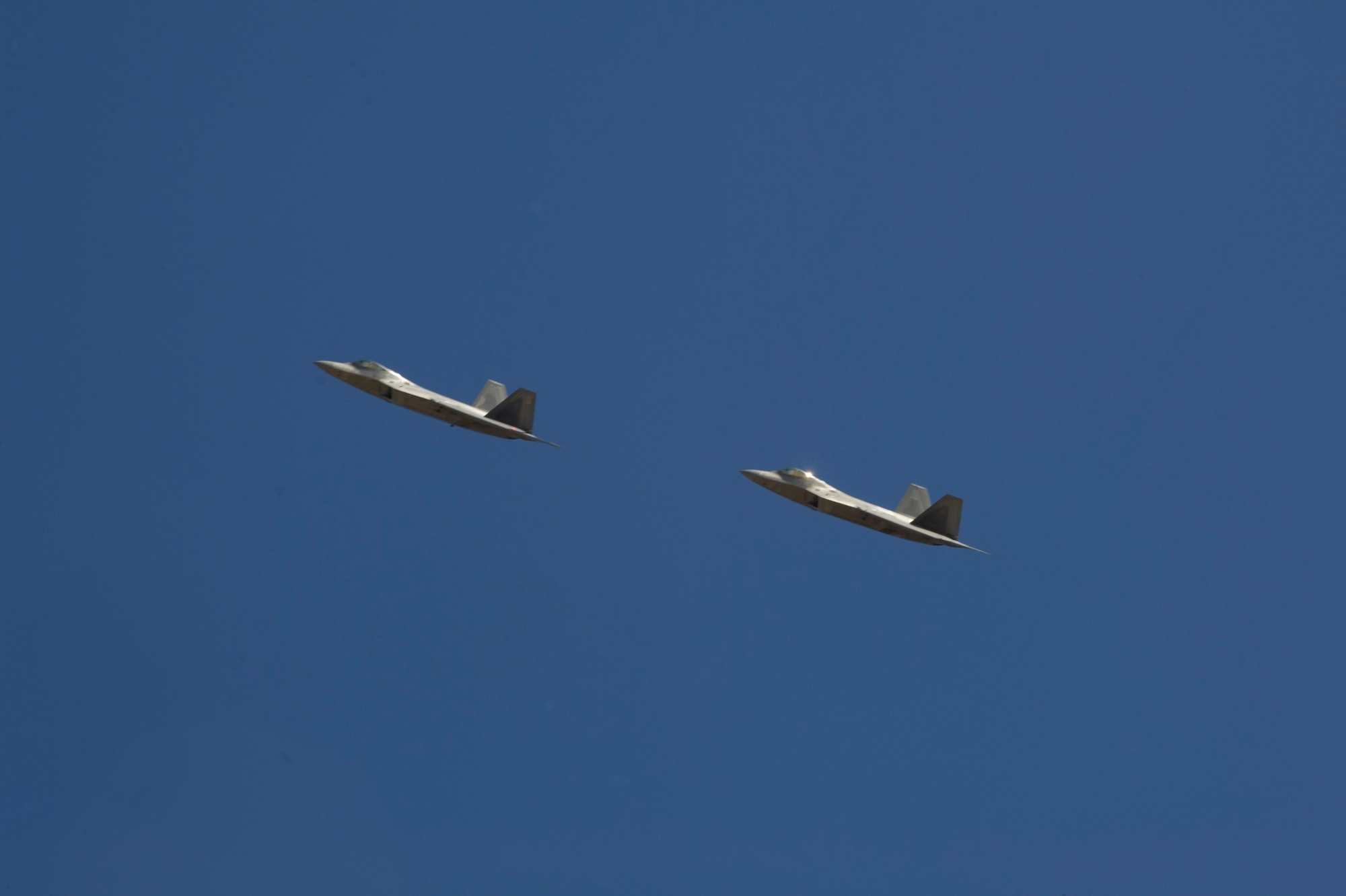 Two F-22 Raptors pass over the New Mexico National Space Museum of History as they return to Holloman Air Force Base N.M., Feb. 20. The F-22’s returned from the final tactical sortie as they begin their departure to Tyndall Air Force Base, FLA., in early April. Members of Team Holloman along with the local community showed their support as they flew by. (U.S. Air Force photo by Airman 1st Class Leah Ferrante/Released) 