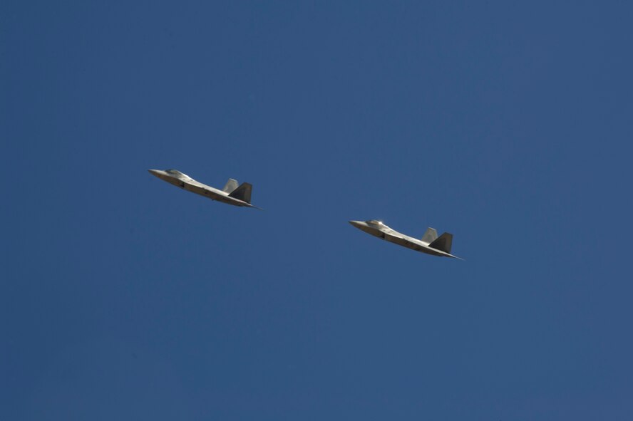 Two F-22 Raptors pass over the New Mexico National Space Museum of History as they return to Holloman Air Force Base N.M., Feb. 20. The F-22’s returned from the final tactical sortie as they begin their departure to Tyndall Air Force Base, FLA., in early April. Members of Team Holloman along with the local community showed their support as they flew by. (U.S. Air Force photo by Airman 1st Class Leah Ferrante/Released) 