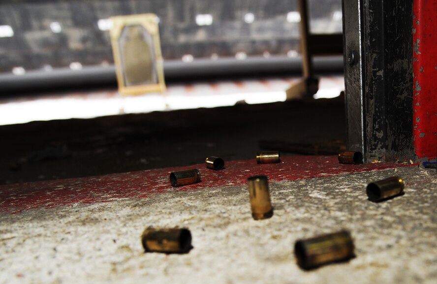 Rounds of spent ammunition from Staff Sgt. Jeremy Smith, 5th Security Forces Combat Arms Training instructor, lay on the ground after firing an M-9 pistol at Minot Air Force Base N.D., Feb. 19, 2014. Smith spends countless hours training base personnel on how to fire, handle and perform basic maintenance on M-9 pistols and M-4 rifles. (U.S. Air Force photo/Senior Airman Andrew Crawford)