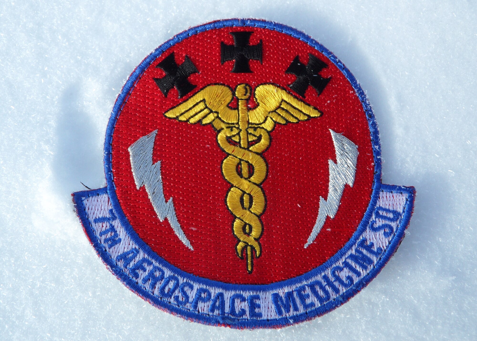 The 7th Aerospace Medicine Squadron patch lies in the snow beneath the South Pole Jan. 10, 2014, at Amundsen-Scott South Pole Station, Antarctica. Maj. Andrew Allen, 7th AMDS, deployed to McMurdo Station in support of Operation Deep Freeze. While stationed there, Allen’s primary mission was to support the flying mission, casualty evacuations and patient movement across the continent. (Courtesy photo)