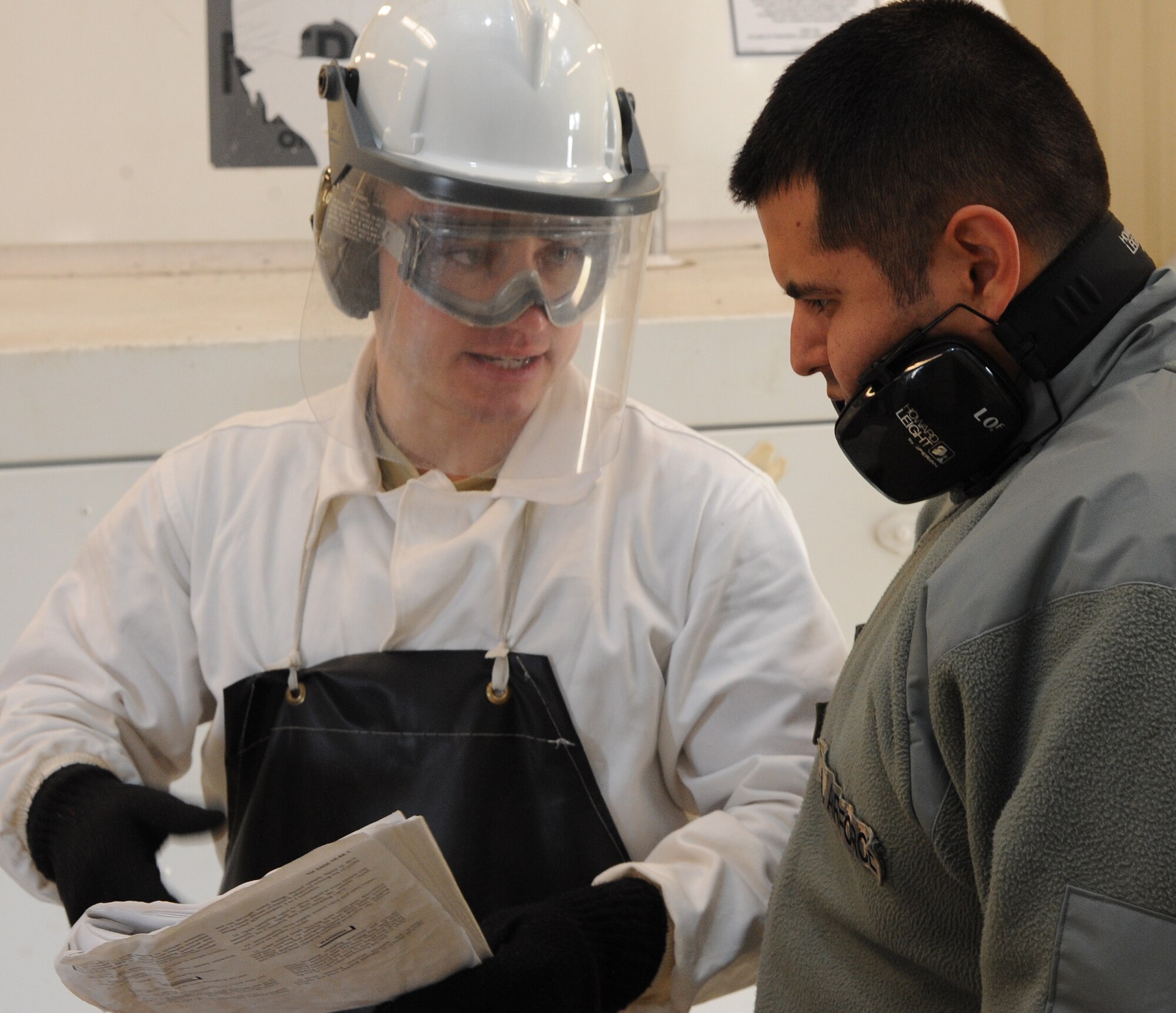 Senior Airman Cole Peck, 5th Logistics Readiness Squadron base fuels laboratory technician, explains a procedure to Staff Sgt. Joseph Guzman, 5th LRS fuels technician,  during extraction of a sample of liquid oxygen to send to Wright Patterson Air Force Base, Ohio. Peck follows checklists during every point of an extraction process to ensure the procedure is executed correctly and safely. (U.S. Air Force photo/Senior Airman Andrew Crawford)