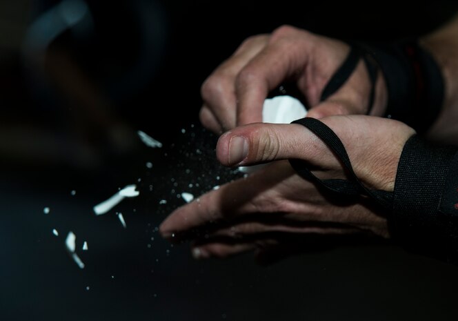 Airman 1st Class Jake Palmer, 628th Medical Group public health technician, rubs chalk on his hands before lifting weights Feb. 19, 2014, at the Fitness Center on Joint Base Charleston – Air Base, S.C. The chalk is used to get a better grip on equipment while performing pulling movements such as deadlifts, pull-ups, rows and cleans. (U.S. Air Force photo/ Airman 1st Class Clayton Cupit)