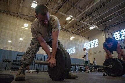 Tech. Sgt. Allen Foster  (left), 437th Maintenance Squadron assistant flight chief, helps Maj. Christopher Marsh, 315th Airlift Wing pilot, secure weights Feb. 19, 2014, at the Fitness Center on Joint Base Charleston – Air Base, S.C. The CrossFit program is designed to be scalable, where every exercise is modified to each individual’s capabilities, making it a great workout regardless of fitness level. (U.S. Air Force photo/ Airman 1st Class Clayton Cupit)