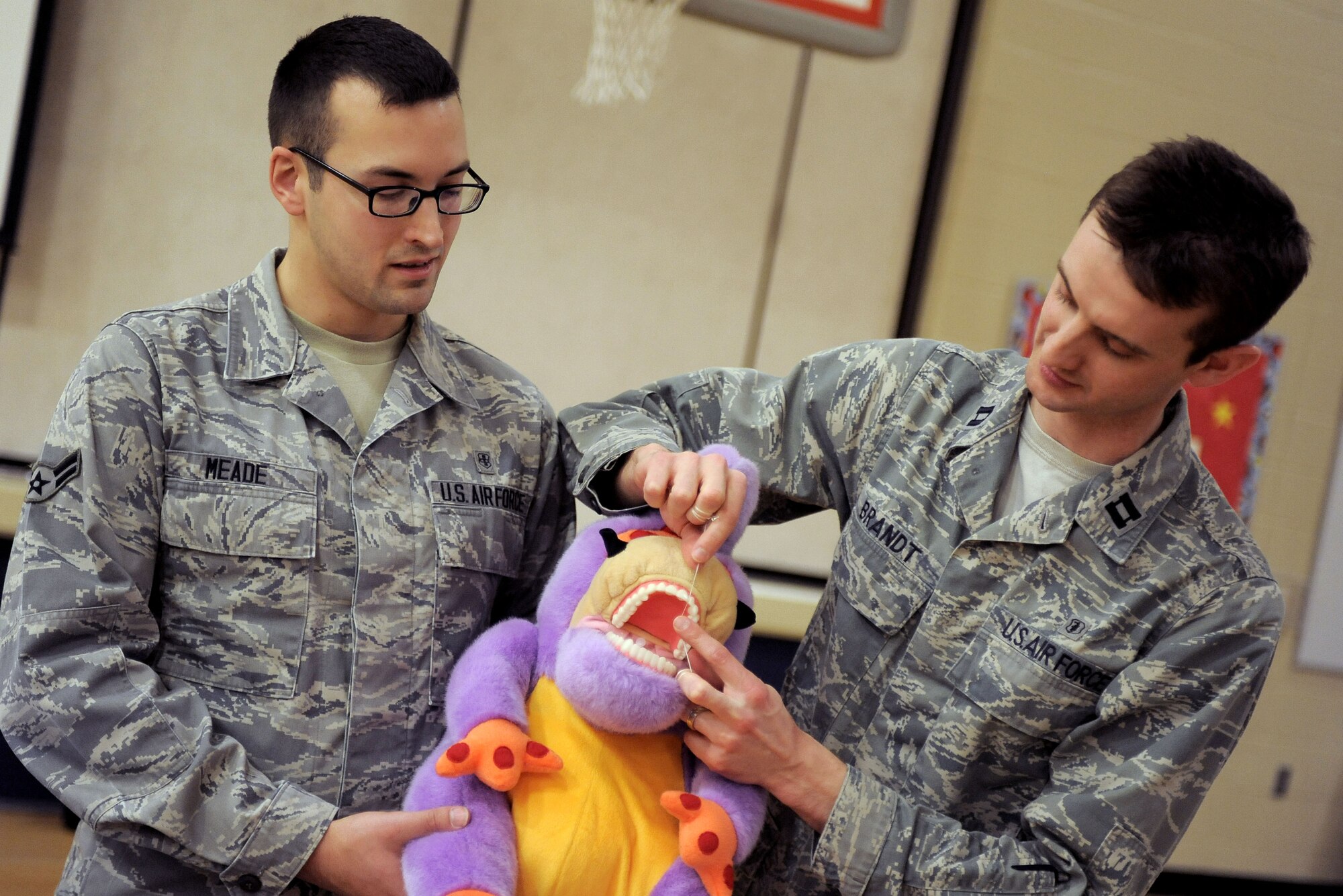 Captain Robert Brandt, 92nd Aerospace Medicine Squadron dentist, and Airman 1st Class Jarrod Meade, 92nd Aerospace Medicine Squadron dental technician, describe to students of Michael Anderson Elementary School, the proper way to floss at Fairchild Air Force Base, Wash., Feb. 20, 2014. The presentation was in honor of National Children’s Dental Health Month. (U.S. Air Force photo by Senior Airman Taylor Curry/Released)