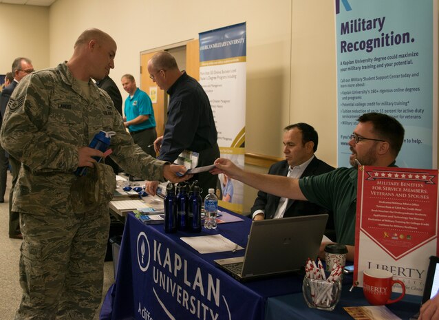 Staff Sgt. Jeremy Landis, 628th Civil Engineer Squadron equipment operator, takes a brochure from Kaplan University representatives at the education fair Feb. 20, 2014, at the Education and Training Center on Joint Base Charleston- Air Base, S.C.  More than 130 prospective students attended the fair and were able to get information from 46 different colleges and universities. The fair was open to all military, family members, retirees and DOD civilians. (U.S. Air Force photo/Senior Airman Ashlee Galloway)