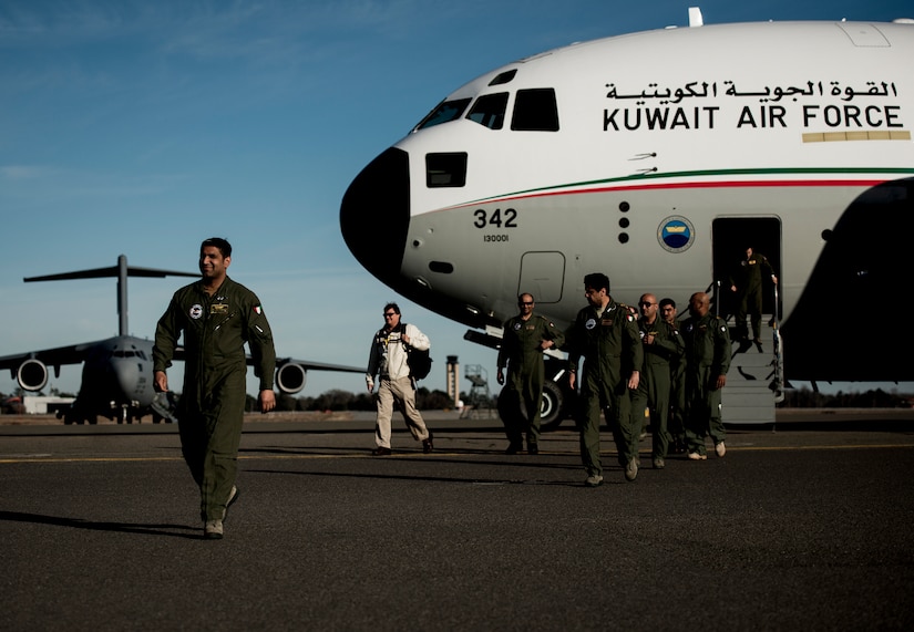 Five members of the Kuwait Air Force exit a C-17 Globemaster III at Joint Base Charleston – Air Base, Feb. 14, 2014, en route to Kuwait, where they delivered their nation’s first C-17. The Kuwait Air Force airmen were embedded with 17th Airlift Squadron for the last month, receiving “seasoning” training on the C-17. (U.S. Air Force photo/ Senior Airman Dennis Sloan)