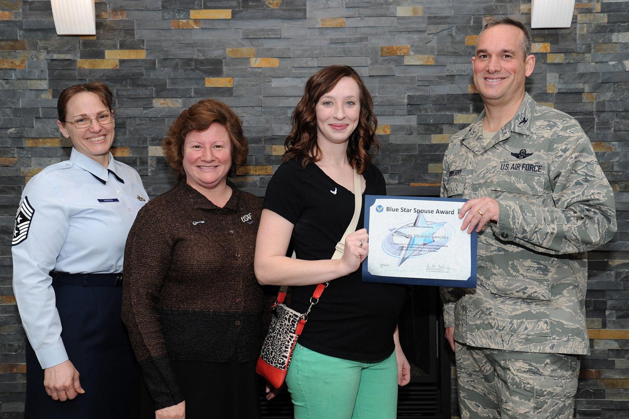 Col. Brian Newberry, 92nd Air Refueling Wing commander, his wife, Jill, and Chief Master Sgt. Wendy Hansen, 92nd ARW Command Chief, present the Blue Star Spouse Award to Mrs. Elisabeth Medina-Sanchez at Fairchild Air Force Base, Wash., Feb. 20, 2014.  Her tireless work as a squadron key spouse supporting Force Support Squadron Airmen and their families kept connections strong during challenging times. She went above and beyond making her squadron family stronger. Anyone interested in nominating someone for the Blue Star Spouse Award should contact their squadron commander. (U.S. Air Force photo by Airman 1st Class Janelle Patiño/Released)