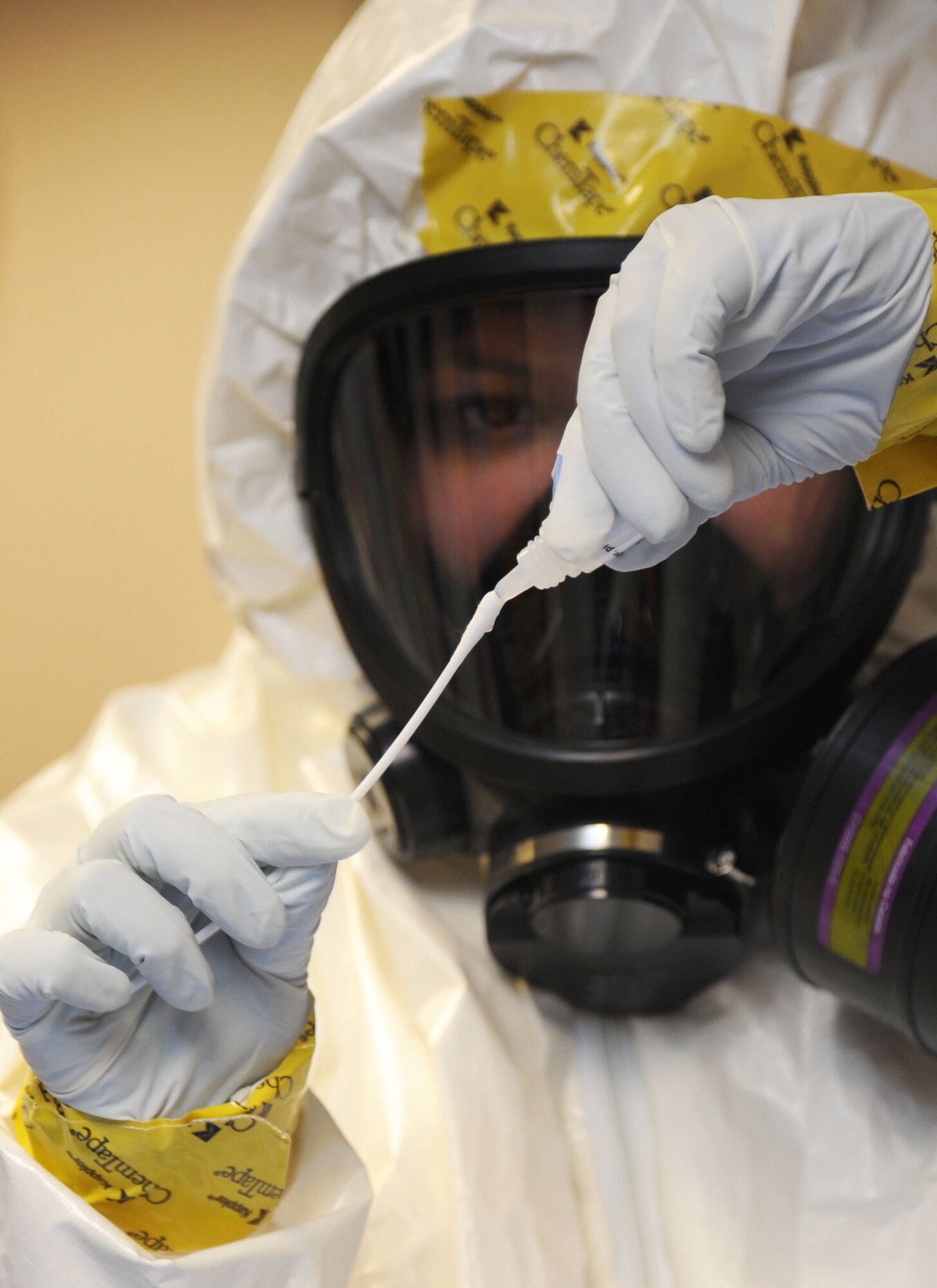 Staff Sgt. Sheila Jones, 81st Aerospace Medicine Squadron bioenvironmental team member, prepares equipment for collecting samples of a simulated biological agent during a Chemical, Biological, Radiological, Nuclear, and high-yield Explosive exercise scenario Feb. 20, 2014, at Wolfe Hall, Keesler Air Force Base, Miss.  The exercise scenario began with a group of Airmen moving old boxes from a storage room where a box containing a bag of powder dropped, causing it to get onto several of the Airmen.  Immediately, the Airmen simulated eye irritations, runny noses, difficulty breathing and burning sensations on their hands and faces from exposure to the agent.  (U.S. Air Force photo by Kemberly Groue)