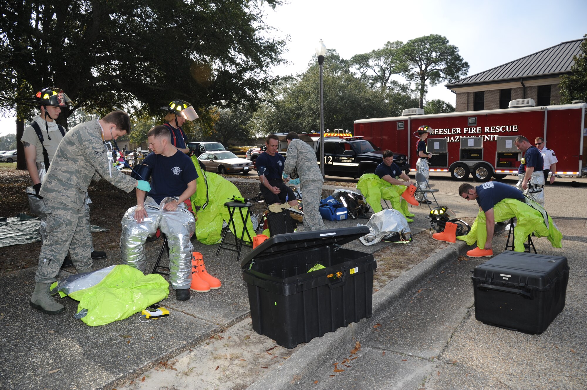 Keesler firefighters get suited up in HAZMAT gear as they prepare to enter the contaminated facility during a Chemical, Biological, Radiological, Nuclear, and high-yield Explosive exercise scenario Feb. 20, 2014, near Wolfe Hall, Keesler Air Force Base, Miss.  The exercise scenario began with a group of Airmen moving old boxes from a storage room where a box containing a bag of powder dropped, causing it to get onto several of the Airmen.  Immediately, the Airmen simulated eye irritations, runny noses, difficulty breathing and burning sensations on their hands and faces from exposure to the agent.  (U.S. Air Force photo by Kemberly Groue)