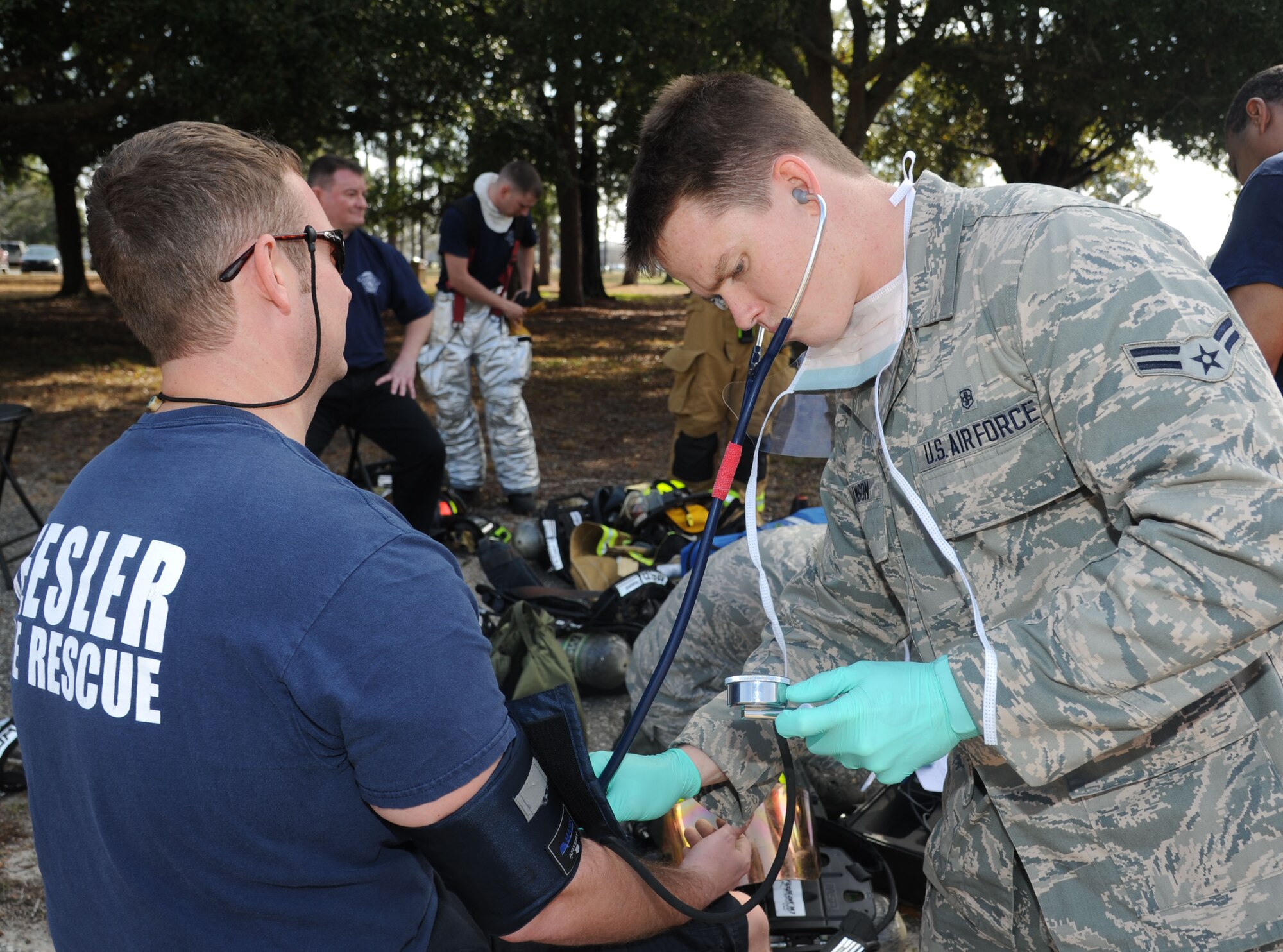 Airman 1st Class James Williamson, 81st Medical Group, checks the vital signs of Daniel Fish, Keesler firefighter, before Fish gets into a protective level-A suit for entry into the contamination zone during a Chemical, Biological, Radiological, Nuclear, and high-yield Explosive exercise scenario Feb. 20, 2014, near Wolfe Hall, Keesler Air Force Base, Miss.  The exercise scenario began with a group of Airmen moving old boxes from a storage room where a box containing a bag of powder dropped, causing it to get onto several of the Airmen.  Immediately, the Airmen simulated eye irritations, runny noses, difficulty breathing and burning sensations on their hands and faces from exposure to the agent.  (U.S. Air Force photo by Kemberly Groue)