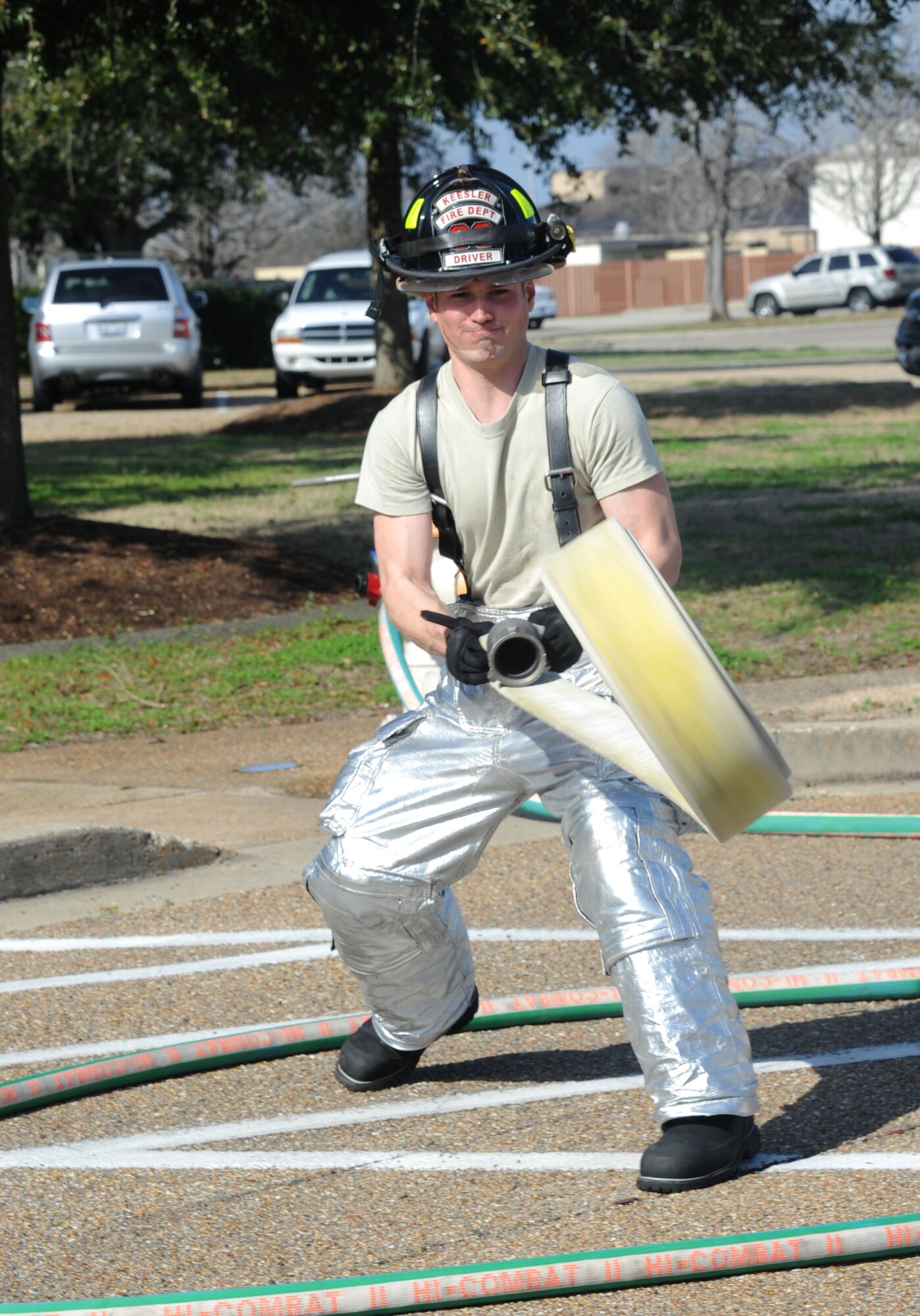 Senior Airman Christopher Lecomte, Keesler firefighter, throws a fire hose to be used for the decontamination site during a Chemical, Biological, Radiological, Nuclear, and high-yield Explosive exercise scenario Feb. 20, 2014, near Wolfe Hall, Keesler Air Force Base, Miss.  The exercise scenario began with a group of Airmen moving old boxes from a storage room where a box containing a bag of powder dropped, causing it to get onto several of the Airmen.  Immediately, the Airmen simulated eye irritations, runny noses, difficulty breathing and burning sensations on their hands and faces from exposure to the agent.  (U.S. Air Force photo by Kemberly Groue)