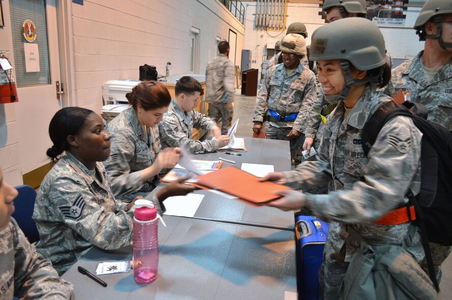 Senior Airman Jessica Cruz, 3d Aerial Port Squadron, gets her mobility folder checked by Staff Sgt. Justina Gholston, 43d Force Support Squadron, while processing through the personnel deployment function line during a 43d Airlift Group mobility exercise here Feb. 20. The four-day exercise prepared 153 personnel and 200 short tons of equipment for deployment. The objectives of the exercise were to assess and evaluate the readiness of the Group, the installation deployment plan, identify process improvement opportunities, command and control, 24-hour operations and fulfill deployment planning and execution requirement to exercise personnel and cargo deployment functions at Pope Army Airfield, Fort Bragg, N.C. (U.S. Air Force photo/Marvin Krause)