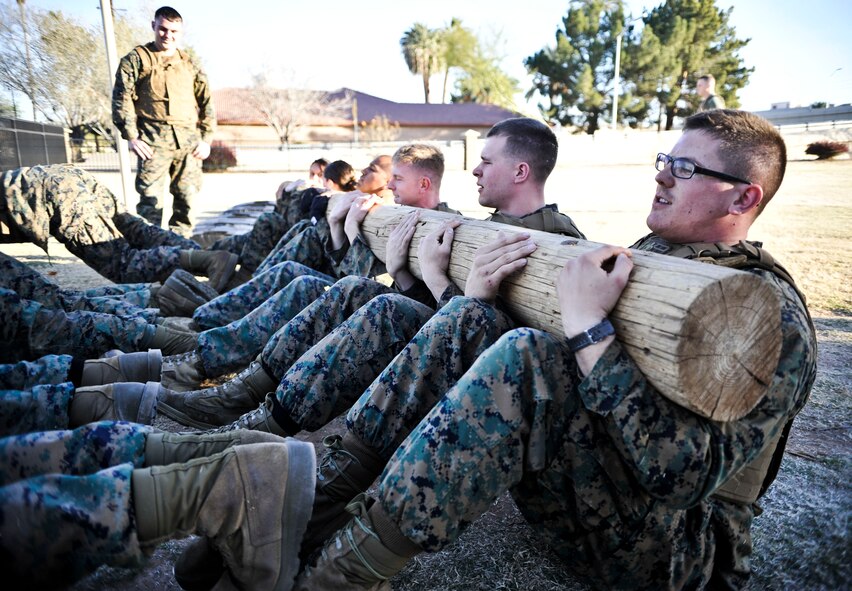 Members of Marines Bulk Fuel Company C perform log crunches while other Marines perform crunches during the Marine Corps Martial Arts Program instructor training course Feb. 14 at the Luke Air Force Base soccer field. (U.S. Air Force photo/Senior Airman David Owsianka)
