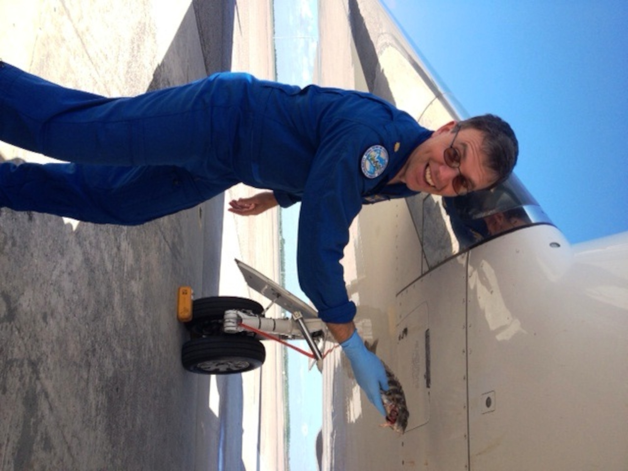Lt. Cmdr. Nick Toth, National Oceanic and Atmospheric Administration pilot, holds the 9-inch sheepshead that struck his aircraft next to the point of impact at MacDill Air Force Base, Fla., Sept. 10, 2013. No damage was inflicted to the aircraft, and all aircrew walked away unharmed. (Courtesy photo/Released)
