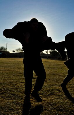 Marine Corporal Alan Geren, Bulk Fuel Company C heavy equipment operator, carries Marine Sergeant Ben Cordes, Bulk Fuel Company C section leader, during a fireman carry Feb. 14 during Marine Corps Martial Arts Program instructor training course at the Luke Air Force Base soccer field. (U.S. Air Force photo/Senior Airman David Owsianka)