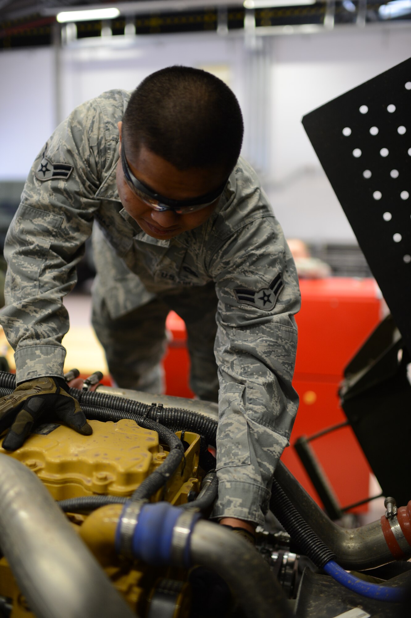 U.S. Air Force Airman 1st Class Evin Diaz, 606th Air Control Squadron vehicle maintenance technician from Guam, checks a five-ton troop carrier vehicle’s engine belt tension on Spangdahlem Air Base, Germany, Feb. 20, 2014. The belt tension must be check on the vehicle during regular maintenance to reduce the chance of engine malfunction. (U.S. Air Force photo by Senior Airman Gustavo Castillo/Released)