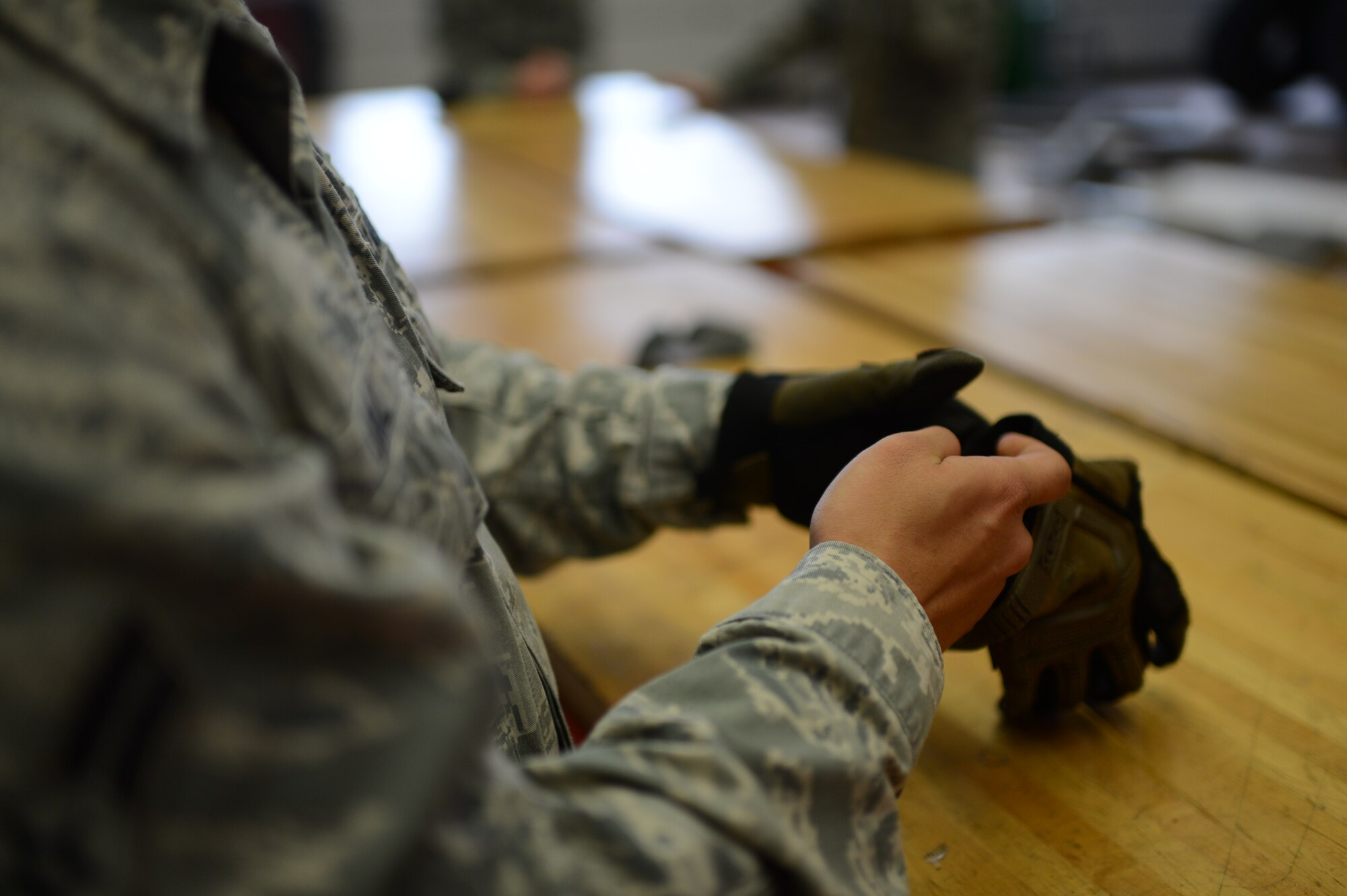 U.S. Air Force Airman 1st Class Evin Diaz, 606th Air Control Squadron vehicle maintenance technician from Guam, slides his hands in to gloves on Spangdahlem Air Base, Germany, Feb. 20, 2014. Personal protective equipment must be used when working on vehicles to reduce the chance of injury to occur. (U.S. Air Force photo by Senior Airman Gustavo Castillo/Released)