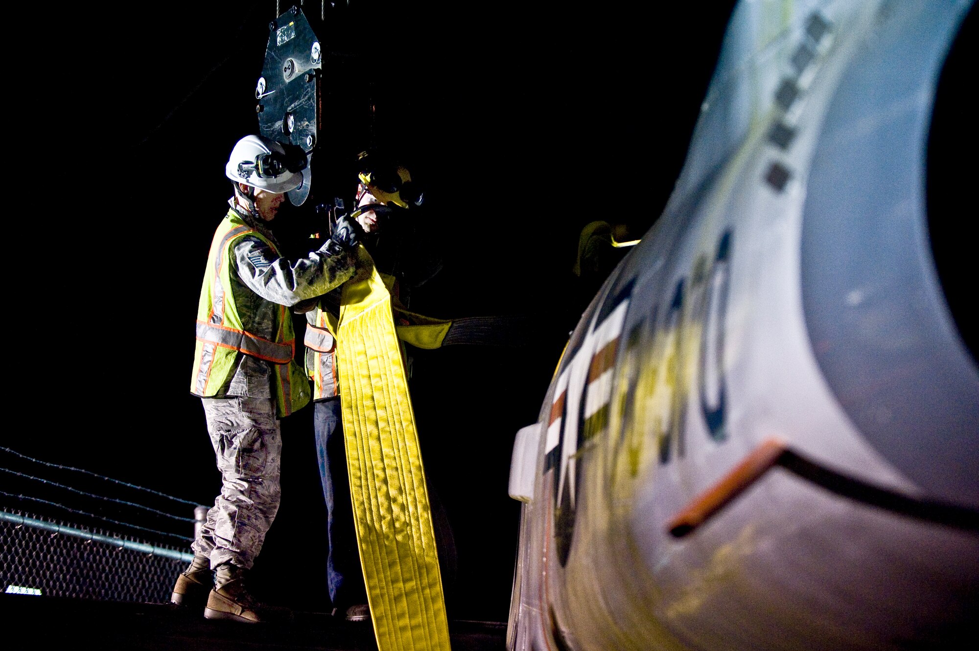 Tech. Sgt. Garrett Faust, 4th Equipment Maintenance Squadron repair and reclamation (R&R) assistant section chief, and Senior Airman Mitchel Caporuscio, 4th EMS R&R technician, secure an F-86 Sabre aircraft to a crane to lift it over the perimeter gate, Feb. 20, 2014, at Seymour Johnson Air Force Base, N.C.  Airmen from the 4th EMS will repaint the exterior and potentially fix structural damage to restore the aircraft, which belongs to the Goldsboro Police Department, during the next few months. Once completed, the aircraft will be returned to city for display. (U.S. Air Force photo by Airman 1st Class Brittain Crolley)