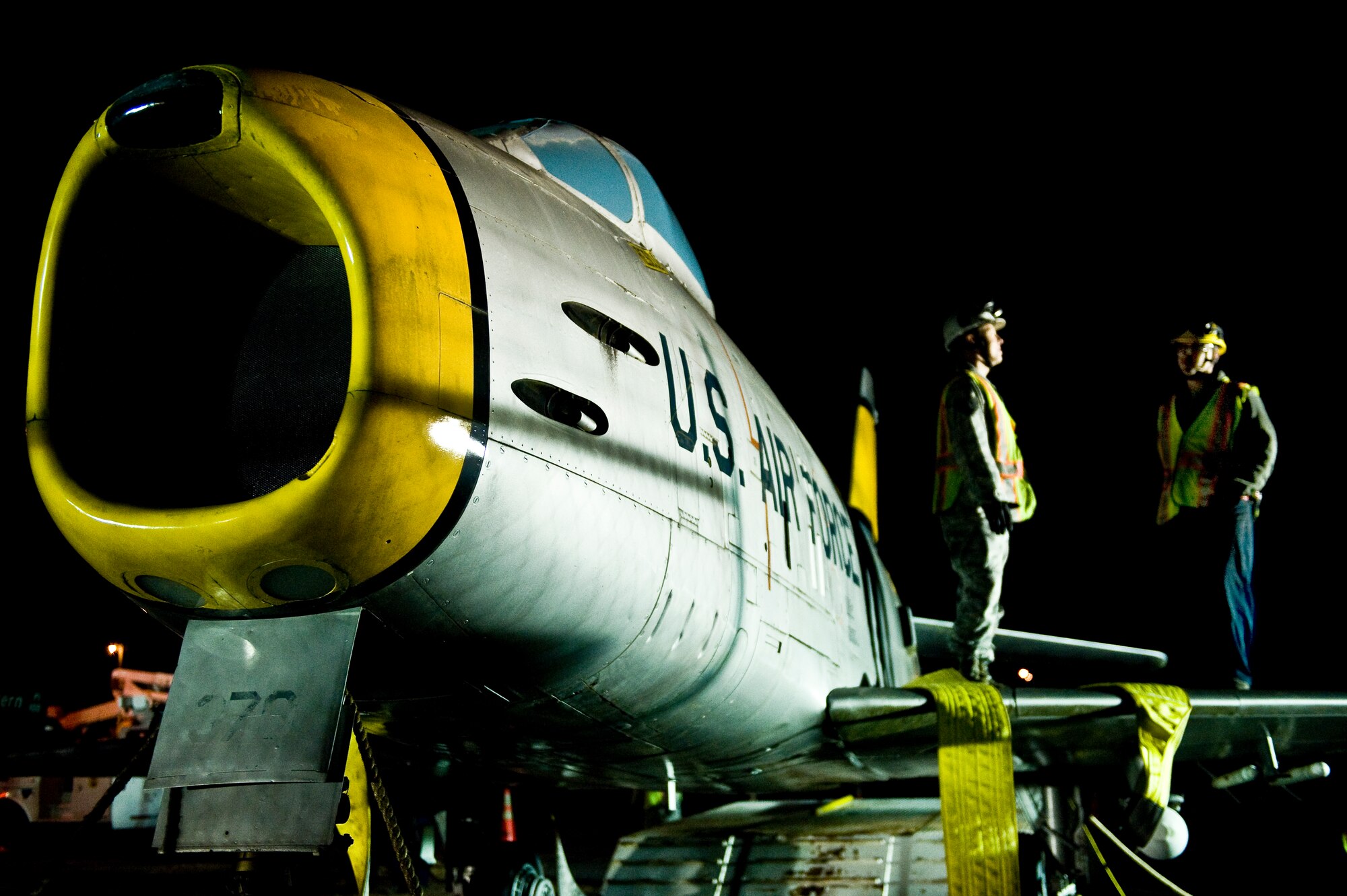 Tech. Sgt. Garrett Faust, 4th Equipment Maintenance Squadron repair and reclamation (R&R) assistant section chief, and Senior Airman Mitchel Caporuscio, 4th EMS R&R technician, wait to secure an F-86 Sabre aircraft to a crane to lift it over the perimeter gate, Feb. 20, 2014, at Seymour Johnson Air Force Base, N.C. Airmen from the 4th EMS will restore the aircraft, which belongs to the Goldsboro Police Department, during the next few months to fix structural and cosmetic flaws.  Once completed, the aircraft will be returned to city for display.  (U.S. Air Force photo by Airman 1st Class Brittain Crolley)