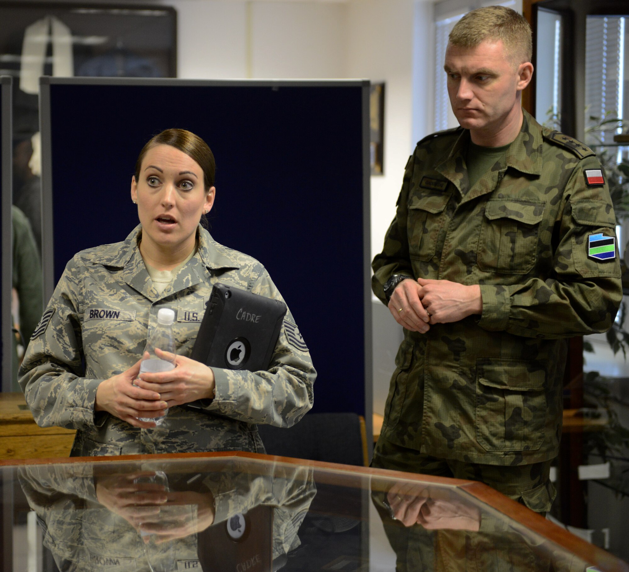 KAPAUN AIR STATION, Germany -- Tech. Sgt. Lacey Brown, an instructor for the Kisling Non-Commissioned Officer Academy here, explains the historical importance of some of the items in the Heritage Room at the academy, while Warrant Officer 1st Class Krzysztof Gadowski, senior enlisted leader for the General Command of the Polish armed forces, listens in during a tour of the facility here Feb. 20, 2014. The tour was part of the Kaiserslautern Military Community First Sergeant Council's Additional Duty First Sergeant Symposium which featured international attendees for the first time in its history.  (U.S. Air Force Photo by Tech. Sgt. James M. Hodgman)