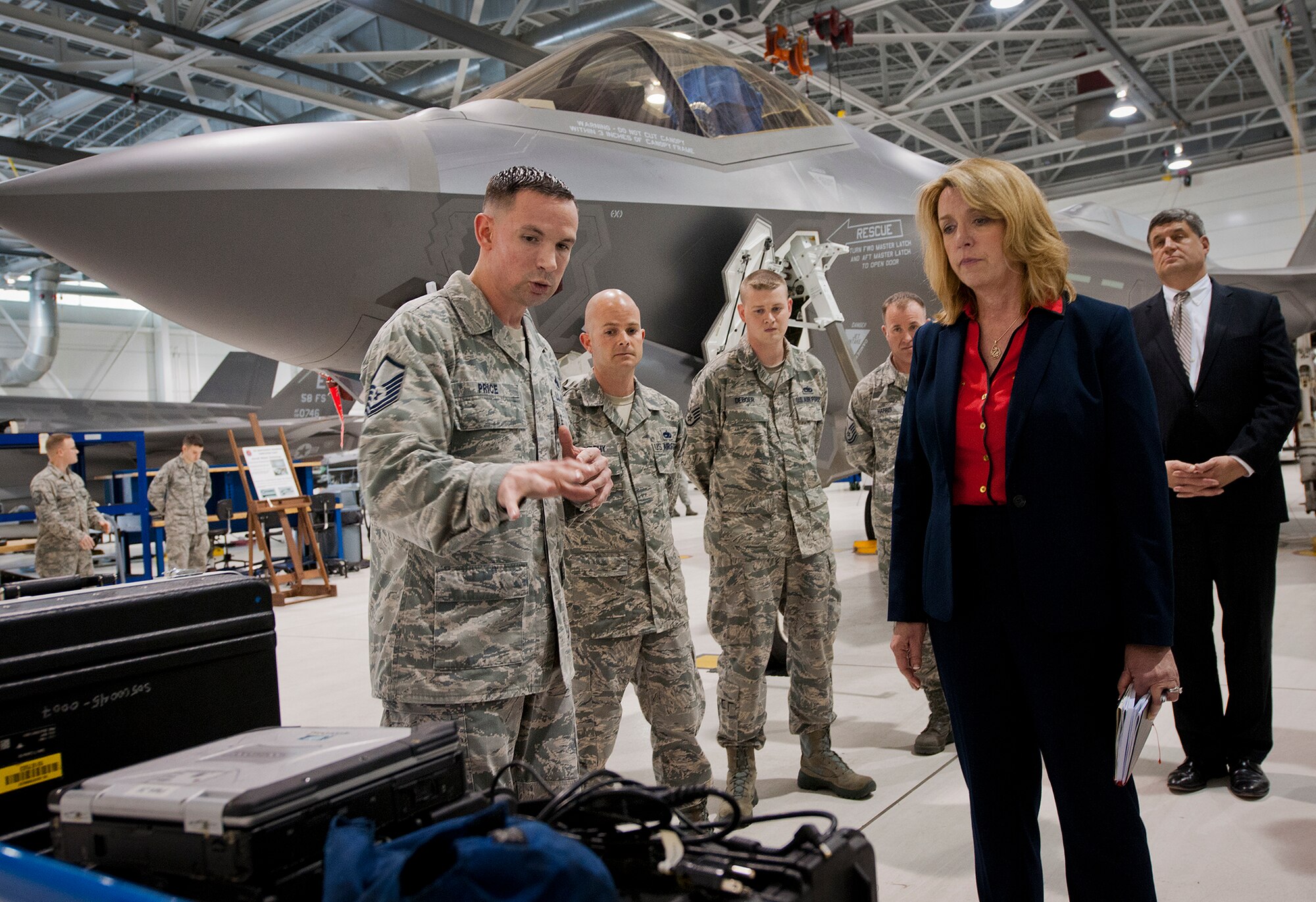 Master Sgt. Donald Price, of the 33rd Aircraft Maintenance Squadron, briefs Secretary of the Air Force Deborah Lee James on local tool innovations created to help maintainers work on the F-35A Lightning II Feb. 19 at Eglin Air Force Base, Fla.  James’ visit focused primarily on the joint strike fighter with visits to the Academic Training Center and reprograming lab and meeting with pilots and maintainers.  (U.S. Air Force photo/Samuel King Jr.)