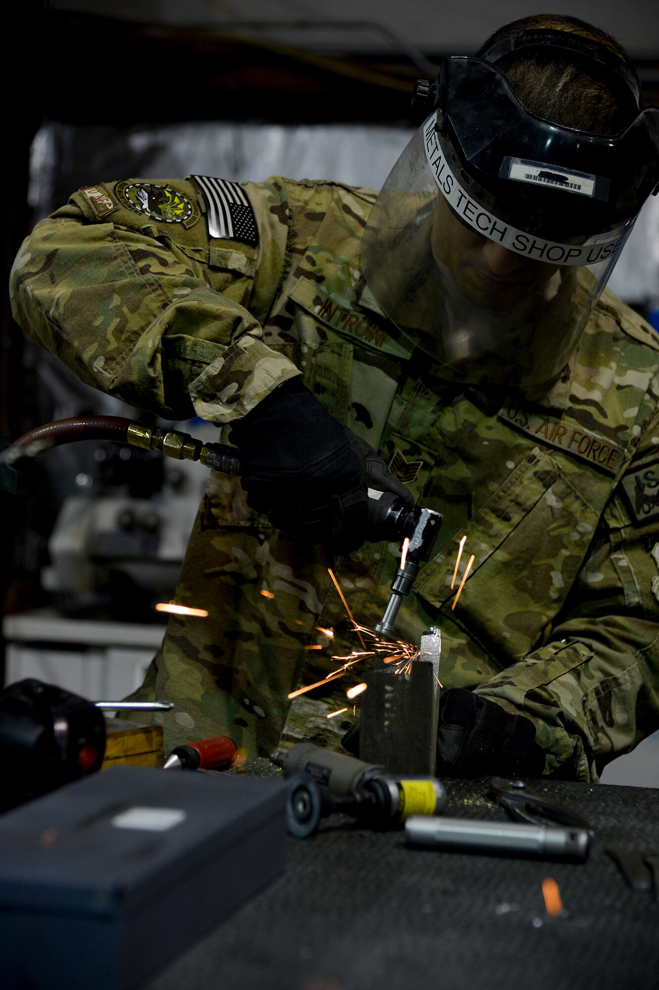 U.S. Air Force Tech. Sgt. Alex Introini, 455th Expeditionary Maintenance Squadron aircraft machinist and welder, grinds an aircraft part at Bagram Airfield, Afghanistan, Feb. 20, 2014. Introini manufactured a forward fuel pylon attach fitting wrench kit to be used for the external fuel tank pylons on the F-16 Fighting Falcons. Introini is deployed from Homestead Air Reserve Base, Fla., and a native of Miami, Fla. (U.S. Air Force photo by Senior Airman Kayla Newman/Released)