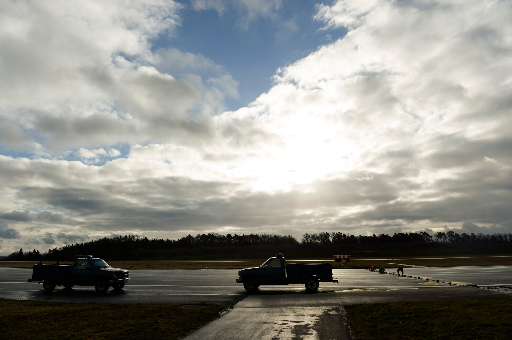 Members of the 52nd Civil Engineer Squadron electrical power production barrier maintenance shop tie down a barrier cable on the runway Feb. 21, 2014, at Spangdahlem Air Base, Germany. The members of the 52nd CES electrical power production barrier maintenance shop maintain four sets of cables on the runway. (U.S. Air Force photo by Senior Airman Rusty Frank/Released)