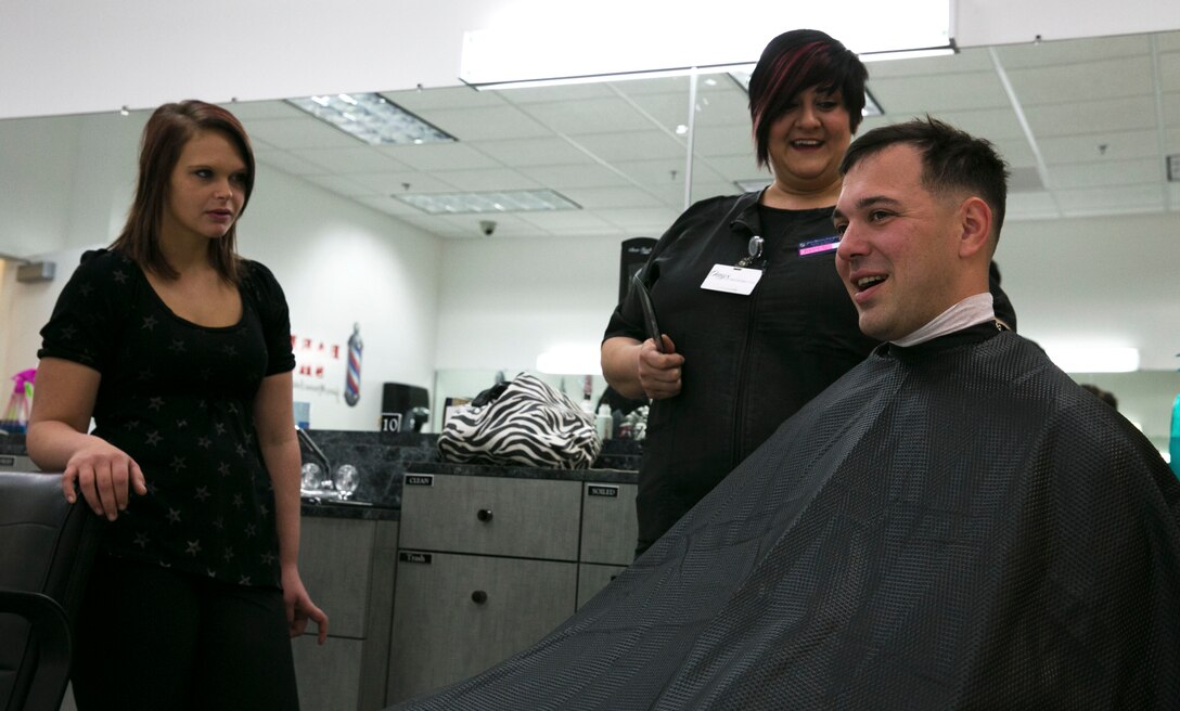 Jodey Sifford, 17, a 12th grader in high school, watches as Amy Gibbons, barber manager, cuts hair at the Combat Center Exchange Barbershop during the 11th Annual Job Shadowing Event, Feb. 19, 2014. The students had the opportunity to choose from a variety of occupational specialties including: mechanics, artillery, food services, medical, interior design, aircraft maintenance, photography, journalism, K9 handling, welding and more. (Official Marine Corps Photo By Lance Cpl. Kasey Peacock/Released)