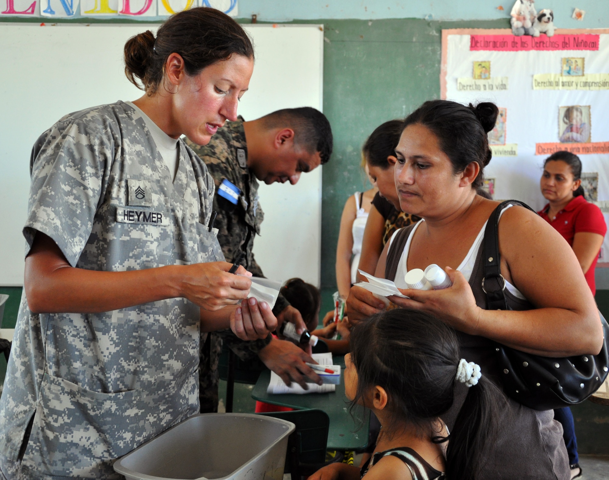 U.S. Army Staff Sgt. Miranda Heymer instructs a Honduran woman on taking medication during a Medical Readiness Training Exercise (MEDRETE) conducted by Joint Task Force-Bravo's Medical Element (MEDEL) in the village of Kele Kele, Department of Puerto Cortes, Honduras, Feb. 26, 2014.  MEDEL, with support from JTF-Bravo Joint Security Forces, Army Forces Battalion, and the 1-228th Aviation Regiment, partnered with the Honduran Ministry of Health, the Honduran Red Cross, and the Honduran military to provide medical care to more than 1,100 people over two days in Kele Kele and Caoba, two remote villages in the Puerto Cortes region of Honduras.  (Photo by U.S. Army Sgt. Courtney Kreft)