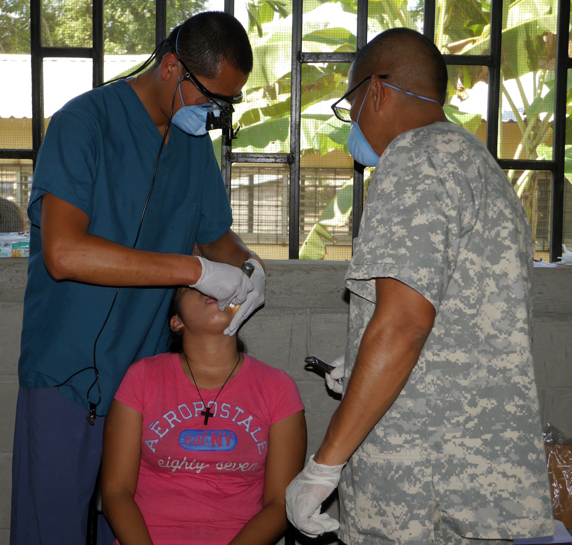 U.S. Army Lt. Col. Wing Djaya and U.S. Army Spc. Harold Aguirre perform a dental procedure during a Medical Readiness Training Exercise (MEDRETE) conducted by Joint Task Force-Bravo's Medical Element (MEDEL) in the village of Kele Kele, Department of Puerto Cortes, Honduras, Feb. 26, 2014.  MEDEL, with support from JTF-Bravo Joint Security Forces, Army Forces Battalion, and the 1-228th Aviation Regiment, partnered with the Honduran Ministry of Health, the Honduran Red Cross, and the Honduran military to provide medical care to more than 1,100 people over two days in Kele Kele and Caoba, two remote villages in the Puerto Cortes region of Honduras.  (Photo by U.S. Army Sgt. Courtney Kreft)