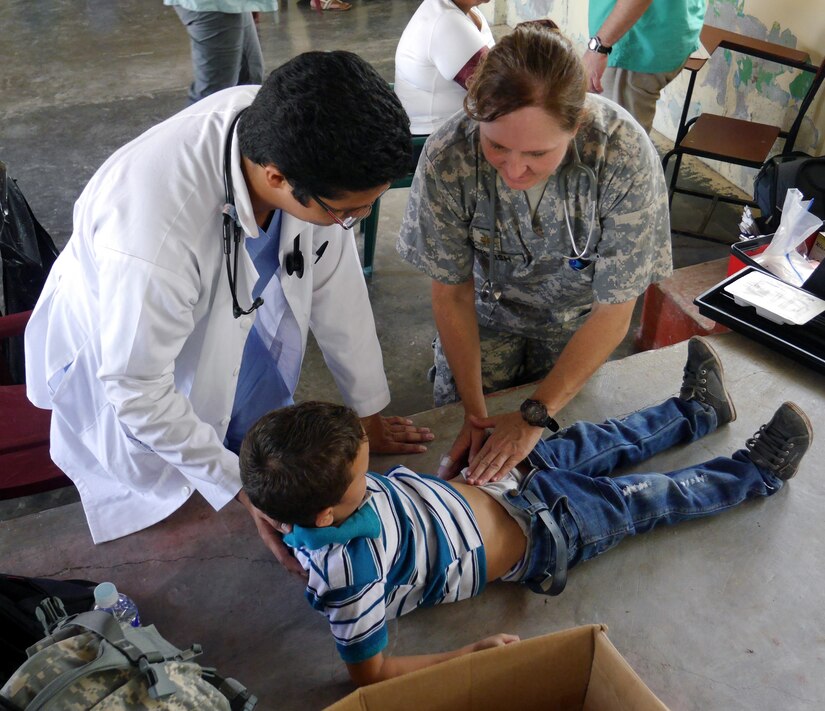U.S. Army Maj. Vicki English and a Honduran medical professional examine a young Honduran child during a Medical Readiness Training Exercise (MEDRETE) conducted by Joint Task Force-Bravo's Medical Element (MEDEL) in the village of Kele Kele, Department of Puerto Cortes, Honduras, Feb. 26, 2014.  MEDEL, with support from JTF-Bravo Joint Security Forces, Army Forces Battalion, and the 1-228th Aviation Regiment, partnered with the Honduran Ministry of Health, the Honduran Red Cross, and the Honduran military to provide medical care to more than 1,100 people over two days in Kele Kele and Caoba, two remote villages in the Puerto Cortes region of Honduras.  (Photo by U.S. Army Sgt. Courtney Kreft)