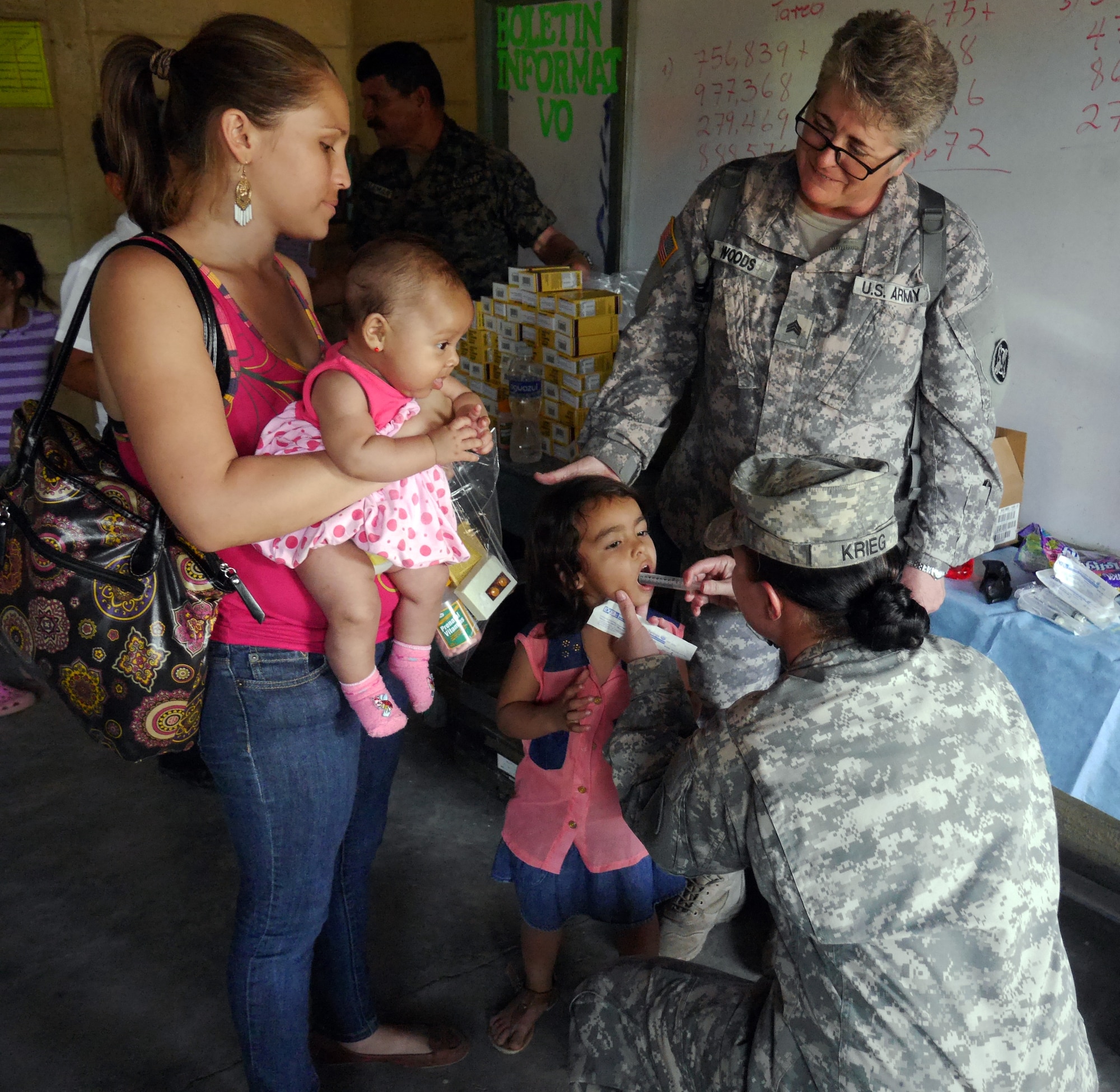 U.S. Army Sgt. Michelle Krieg and U.S. Army Sgt. Melissa Woods administer medication to a Honduran child during a Medical Readiness Training Exercise (MEDRETE) conducted by Joint Task Force-Bravo's Medical Element (MEDEL) in the village of Kele Kele, Department of Puerto Cortes, Honduras, Feb. 26, 2014.  MEDEL, with support from JTF-Bravo Joint Security Forces, Army Forces Battalion, and the 1-228th Aviation Regiment, partnered with the Honduran Ministry of Health, the Honduran Red Cross, and the Honduran military to provide medical care to more than 1,100 people over two days in Kele Kele and Caoba, two remote villages in the Puerto Cortes region of Honduras.  (Photo by U.S. Army Sgt. Courtney Kreft)