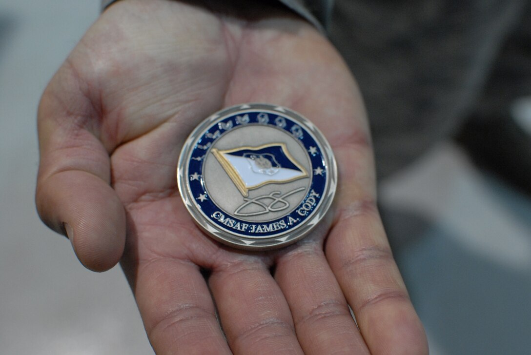 Tech. Sgt. Brian Sommers, 193 Special Operations Wing air cargo specialist, shows the coin he was presented by the Air Force’s top enlisted member, Chief Master Sgt. of the Air Force James A. Cody. Sergeant Sommers was presented the coin for his for exceptional contributions to the mission. (U.S. Air National Guard photo by Senior Airman Claire Behney/Released)