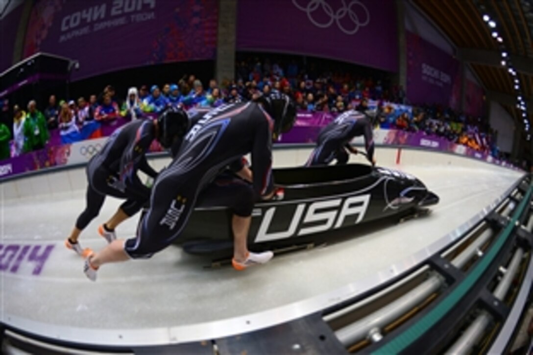 Former U.S. Army World Class Athlete Program and reigning Olympic four-man champion bobsled driver Steven Holcomb, far right, brakeman Capt. Chris Fogt, far left, and USA-1 crew members Steve Langton and Curt Tomasevicz begin their first heat of the Olympic four-man bobsled competition at Sanki Sliding Centre in Krasnaya Polyana, Russia, Feb. 22, 2014. The USA-1 quartet is in third place after one of four heats. 