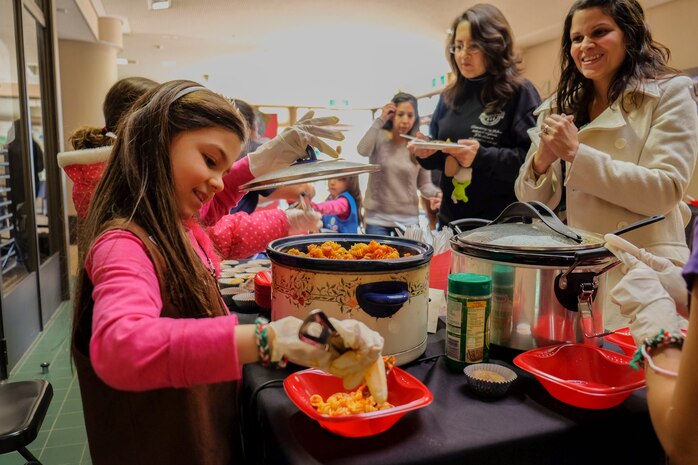 Arianna Pfeil, 8, a Girl Scout with Brownie Troop 92, serves pasta to her mother during World Thinking Day 2014 at the Crossroads Mall aboard Marine Corps Air Station Iwakuni, Japan, Feb. 23, 2014. The Brownies’ study Italy and served a variety of Italian food they discovered through their research. The purpose of World Thinking Day is to teach Girls Scouts they are a part of larger community of more than 10 million Girls Scouts worldwide, according to Hyla Melloy, USA Girl Scouts Overseas co-chairman for Iwakuni.