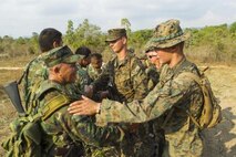 Royal Thai Marine Capt. Jirapan Sukpimai, left, shakes hands with U.S. Marine Lance Cpl. James P. Soccodato Feb. 12 after a full day of jungle patrolling training at Ban Chan Krem, Kingdom of Thailand. Royal Thai Marines and U.S. Marines are currently taking part in Exercise Cobra Gold, which is a multinational and multiservice exercise that takes place annually in the Kingdom of Thailand and was developed by the Thai and U.S. militaries. The day’s training consisted of Royal Thai Marines and U.S. Marines practicing various jungle patrolling tactics, techniques and procedures. Sukpimai is the company commander of 3rd Small Arms Company, 7th Battalion, 3rd Regiment, of the Marine Division. Soccodato is a tactical switching operator with Combat Logistics Battalion 4, Combat Logistics Regiment 3, 3rd Marine Logistics Group, III Marine Expeditionary Force.