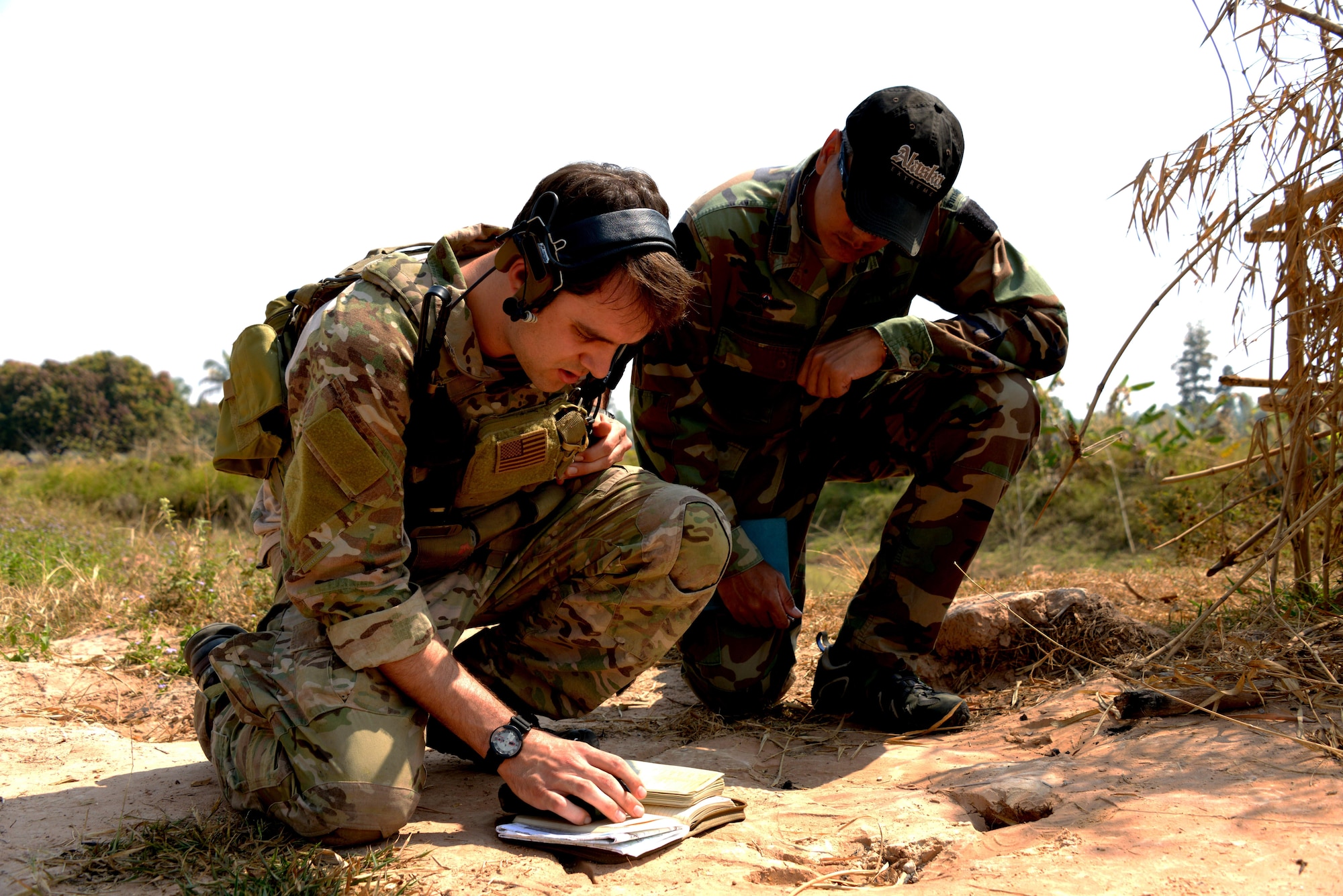 Staff Sgt. Zachary Asmus, a combat controller from the 320th Special Tactics Squadron, demonstrates how to conduct urban close air support as a member from the Royal Thai Air Force 3rd Special Tactics Battalion observes Feb. 4, 2014 in a town near Udon Thani, Thailand. A team of combat controllers from the 320th STS worked with their Thai counterparts during the training exchange, focused on building skills in Joint Terminal Air Control. (U.S. Air Force photo by Tech. Sgt. Kristine Dreyer)