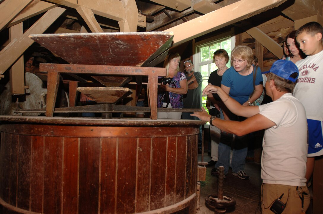 Billy Brown (Right), a licensed miller, explains the process of grinding corn into cornmeal to visitors at Mill Springs Mill during the cornbread festival May 28, 2011.