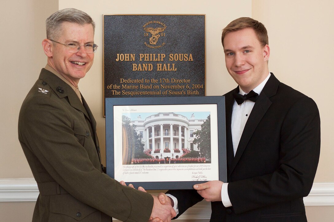 Marine Band Director Col. Michael J. Colburn presents 2014 Concerto Competition winner trombonist Isaac Johnson with a framed photo of the U.S. Marine Band. (U.S. Marine Corps photo by Staff Sgt. Brian Rust/released)