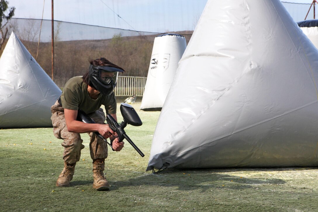 Corporal Jayme Copeland, with Combat Logistics Regiment 17, shields herself from her opponents during the Commanding General’s Cup paintball tournament aboard Camp Pendleton, Calif., Feb. 20, 2014. Four out of the five CLR-17 teams placed in the tournament.