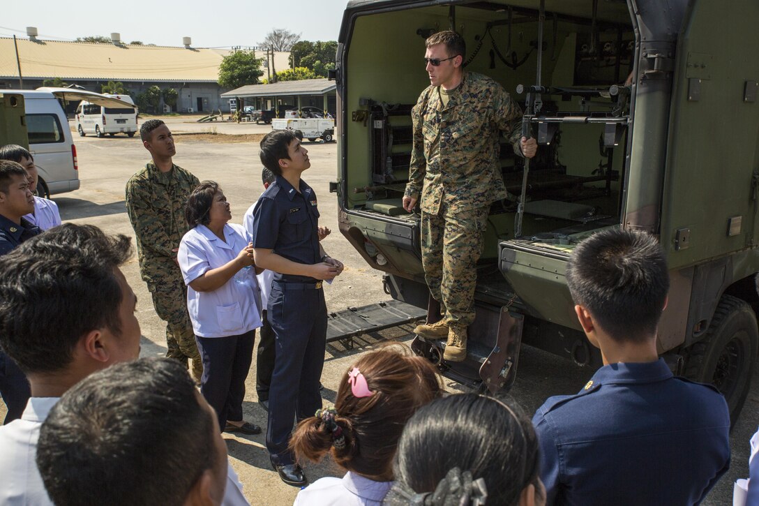 Petty Officer 2nd Class Brenton Smith explains the nomenclature of a M997 ambulance to medical personnel from the Wing One Hospital, Royal Thai Air Force, at the Flight-line Aid Station aboard Wing One Royal Thai Air Force Base, Nakhon Ratchasima, Kingdom of Thailand, Feb. 10 as part of Exercise Cobra Gold 2014. CG 14 is an annual multinational exercise conducted in the Kingdom of Thailand designed to exercise multinational joint interoperability. Smith is an aviation medical technician with Marine All Weather Fighter Attack Squadron 242, Marine Aircraft Group 12, 1st Marine Air Wing, III Marine Expeditionary Force. (U.S. Marine Corps photo by Cpl. James R. Smith/released)