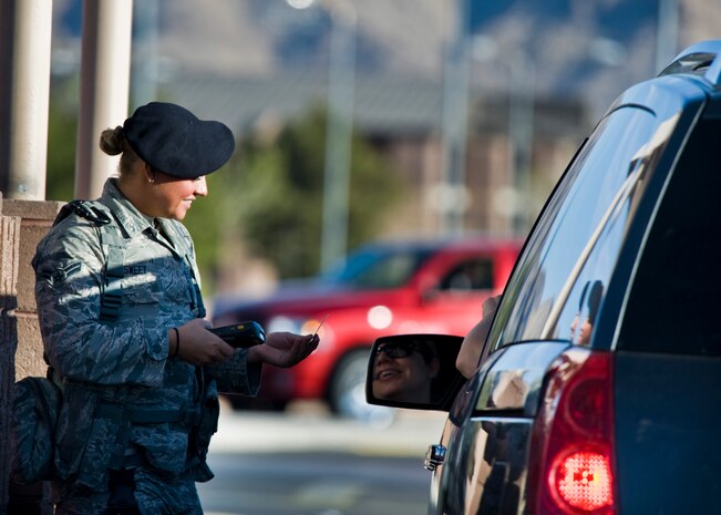 U.S. Air Force Airman 1st Class Taquisha Sweet, 99th Security Forces Squadron SF journeyman, checks a common access card at Beale gate, Feb. 21, 2014, at Nellis Air Force Base, Nev. The 99th SFS provides flight line security, police services, antiterrorism and force protection for Nellis and Creech AFBs (U.S. Air Force photo by Senior Airman Jason Couillard)