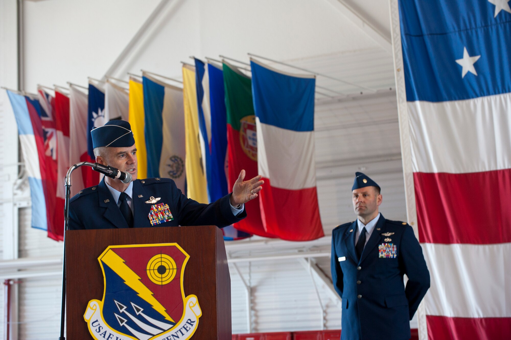 U.S. Air Force Brig. Gen. Jay Silveria, U.S. Air Force Warfare Center incoming commander, speaks to Airmen during an assumption of command ceremony in the Thunderbird hangar Feb. 21, 2014, at Nellis Air Force Base, Nev. Silveria grew up in an Air Force family and is a 1985 graduate of the U.S. Air Force Academy. (U.S. Air Force photo by Senior Airman Matthew Lancaster)